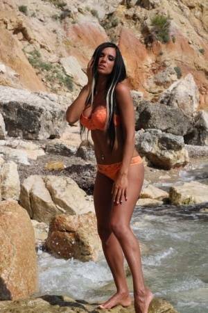 Leggy teen with long hair takes off her bikini in a fast moving stream on leaks.pics