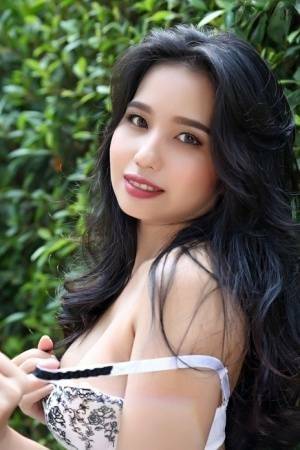 Beautiful Asian girl Norah gets totally naked next to a hedge in a garden on leaks.pics