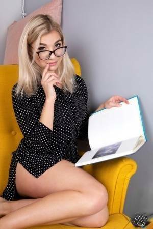 Geeky blonde Amelia undresses on a chair before playing with her shaved pussy on leaks.pics